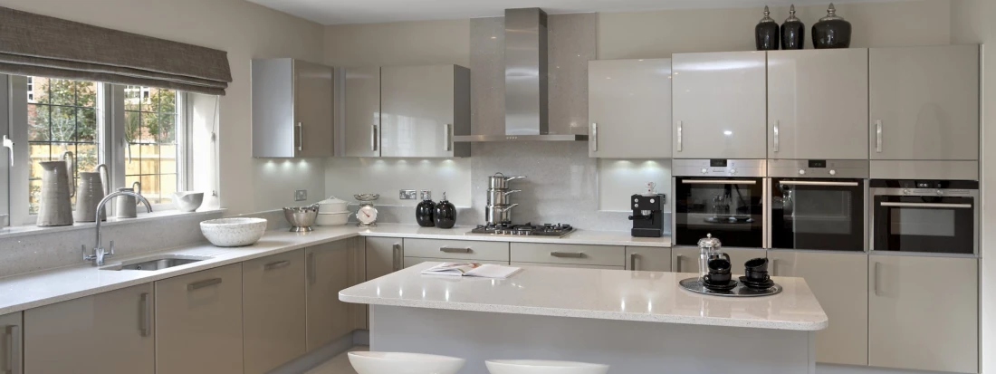White acrylic kitchen with glossy grey surfaces, modern island, integrated appliances and sleek minimalist cabinetry.