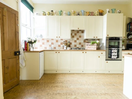 After kitchen renovation with white wooden units and oak accents from the Chatsworth range, showcasing a refreshed space.
