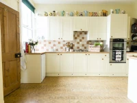After kitchen renovation with white wooden units and oak accents from the Chatsworth range, showcasing a refreshed space.