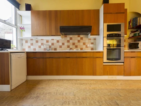 Before kitchen image showing an outdated layout and wooden cabinetry prior to renovation.