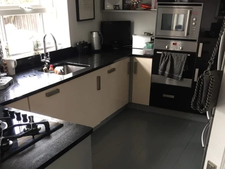 Before kitchen image showing a dark space with outdated cabinetry and low lighting prior to renovation.