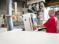 Warehouse worker handling kitchen components as part of the kitchen manufacturing and assembly process.