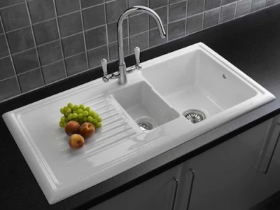 A white ceramic kitchen sink with a chrome faucet.