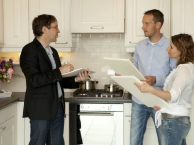 Kitchen Magic employee having a consultation with a client, discussing kitchen design options and plans.
